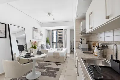 a kitchen and living room with a bed and a table at Stonetree - Goldcrest Views 2 - Prime Location in Dubai