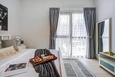 a bedroom with a bed and a large window at Trophy - Discover Tranquility Living in this Sleek Sanctuary in Dubai