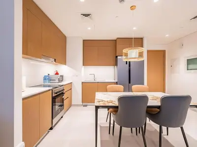 a kitchen with a table and chairs in a kitchen at Ravishing Retreat 2BR Creek Beach Luxury Abode in Dubai