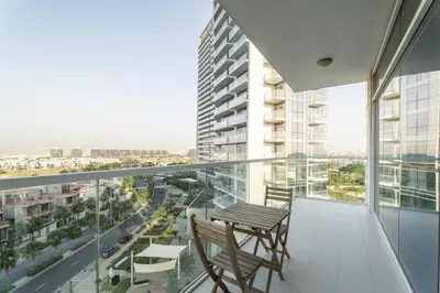 a balcony with two chairs and a view of a city at Nasma Luxury Stays - Charming Studio at DAMAC Hills Artesia Tower C in Dubai