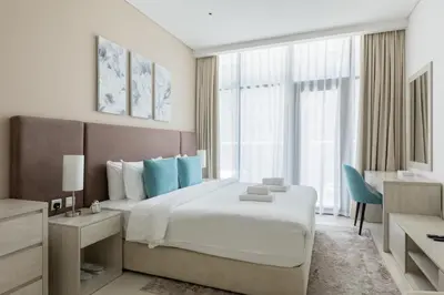 a bedroom with a large bed and a large window at Chic Palm Studio with Infinity Pool in Dubai