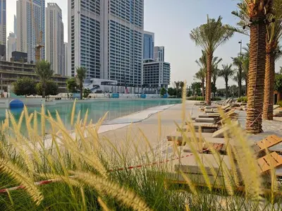 a park with benches and palm trees in a city at Serenity Cove: 1BR Luxury Beach Retreat in Dubai