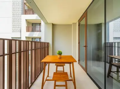 a table on a balcony with a potted plant on it at Serenity Cove: 1BR Luxury Beach Retreat in Dubai