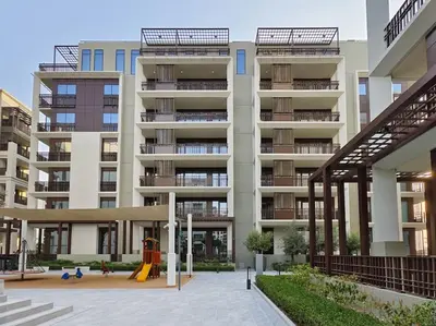 an apartment building with a playground in front of it at Serenity Cove: 1BR Luxury Beach Retreat in Dubai