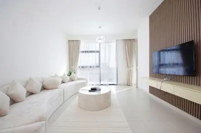 a white living room with a couch and a tv at Park Point C-1 bedroom for monthly stay-1003 in Dubai
