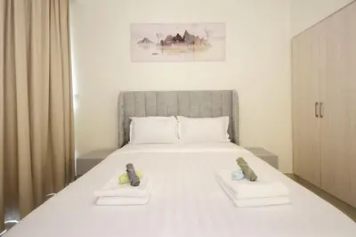 a bedroom with a large white bed with two slippers at Park Point C-1 bedroom for monthly stay-1003 in Dubai