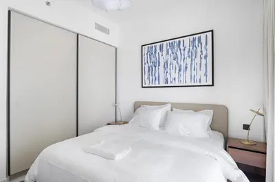 a white bedroom with a large bed with white pillows at Silkhaus Sea & Palm View 1BDR in Marina Vista in Dubai