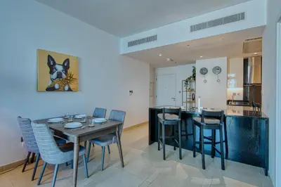 a dining room and kitchen with a table and chairs at Luxury 1BR Apartment in Dubai Marina Gate in Dubai