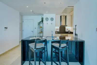 a kitchen with a glass table and two chairs at Luxury 1BR Apartment in Dubai Marina Gate in Dubai