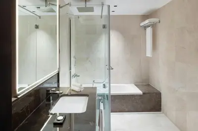a bathroom with a shower and a sink and a tub at Marriott Hotel Production City, Dubai in Dubai
