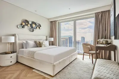 a bedroom with a bed and a desk and a large window at Frank Porter - Emaar Residences Dubai Marina in Dubai
