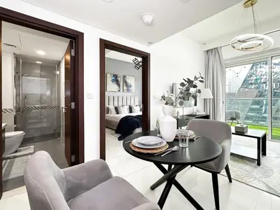 a living room with a table and chairs and a bathroom at Trophy - Springs Suite with Cozy Balcony Garden in Dubai