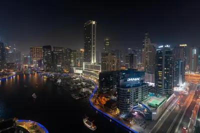 a city skyline at night with a river and buildings at Dubaiashome - Luxury Special Stay in Dubai