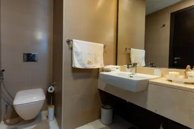 a bathroom with a sink and a toilet and a mirror at Dubaiashome - Luxury Special Stay in Dubai