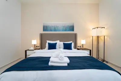 a bedroom with a large bed with towels on it at Marco Polo - Modern 1BR in Business Bay near Burj Khalifa in Dubai