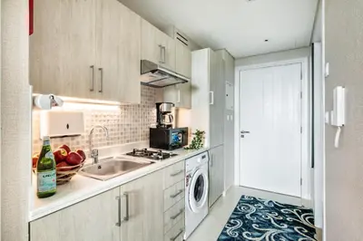 a kitchen with a sink and a washing machine at The Smart Concierge - Seven Palm in Dubai