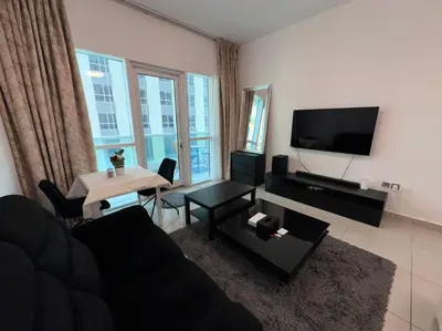 a living room with a couch and a table at Cozy 2 Bedroom Retreat in Dubai