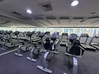 a gym with several rows of cardio bikes and treadmills at Cozy 2 Bedroom Retreat in Dubai