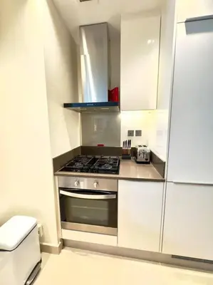 a kitchen with a stove and white cabinets at Dubai Marina Gate 1 Deluxe in Dubai