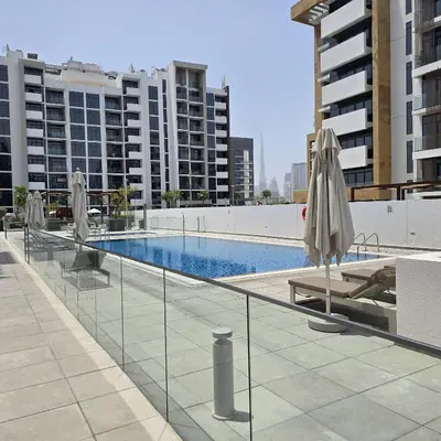a swimming pool with umbrellas on a building at VESTA - Dubai Residence in Dubai