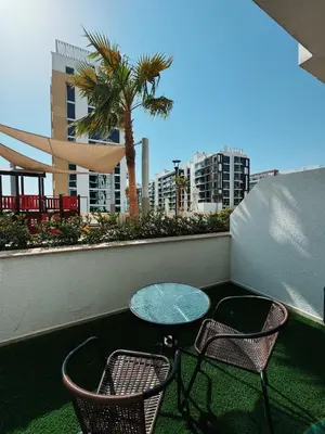 a table and chairs on a balcony with a palm tree at VESTA - Dubai Residence in Dubai