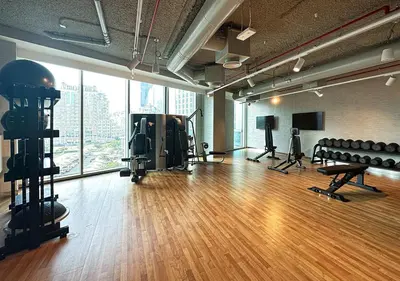 a gym with a wooden floor and a large window at Luxury 2 BR Apartment, 5 Mins to Dubai Mall with Amazing view in DownTown Views 2 in Dubai