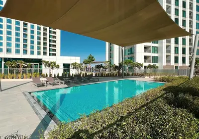 a swimming pool with chairs and a large umbrella at Luxury 2 BR Apartment, 5 Mins to Dubai Mall with Amazing view in DownTown Views 2 in Dubai