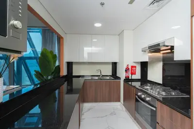 a kitchen with black and white counters and a sink at Escape24 2BR Huge Terrace with Canal View in Dubai