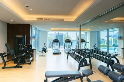 a gym with treadmills and elliptical machines at Escape24 2BR Huge Terrace with Canal View in Dubai