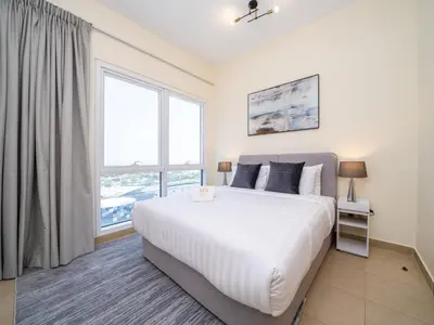 a bedroom with a large bed and a large window at Spacious 2 Bedroom Apartment in Tecom in Dubai