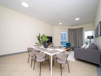 a living room with a table and chairs and a couch at Spacious 2 Bedroom Apartment in Tecom in Dubai