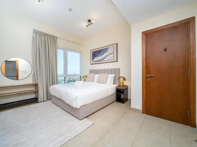 a bedroom with a bed and a large window at Spacious 2 Bedroom Apartment in Tecom in Dubai