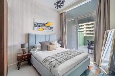a bedroom with a king sized bed and a balcony at GuestReady - Modern living at Reva Residence in Dubai