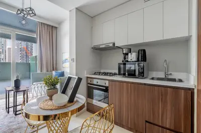 a kitchen with a table and a counter top at GuestReady - Modern living at Reva Residence in Dubai