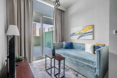 a living room with a blue couch and a window at GuestReady - Modern living at Reva Residence in Dubai