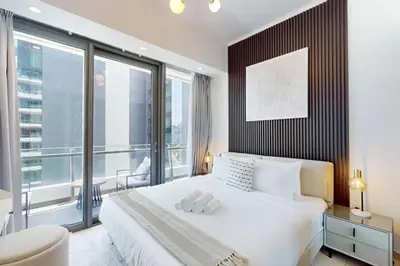 a bedroom with a white bed and a large window at Silverene Tower B - Exciting Two Bedroom in Dubai