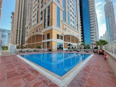 a large swimming pool in the middle of a building at Manzil - 1BR in Elite Residence with Marina View in Dubai