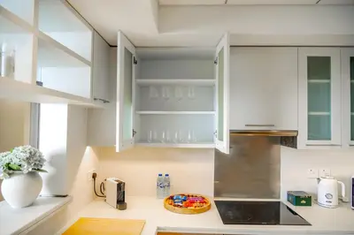 a kitchen with white cabinets and a vase of flowers at Downtown Oasis Luxury One-bed in Downtown Dubai in Dubai