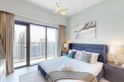 a bedroom with a large bed and a large window at Burj Royale - Central Two Bedroom in Dubai
