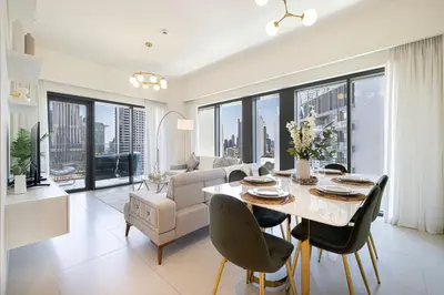 a dining room and living room with a table and chairs at Stunning 2BR Full Burj Khalifa Views 5min walk to Dubai Mall in Dubai
