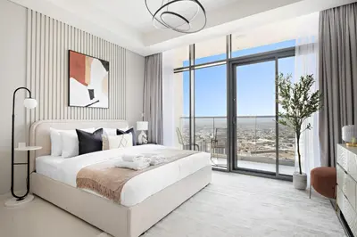 a white bedroom with a large bed and a large window at Silkhaus New High Floor Studio In Business Bay in Dubai