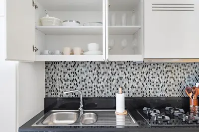 a kitchen with a sink and a stove and cabinets at Silkhaus New High Floor Studio In Business Bay in Dubai