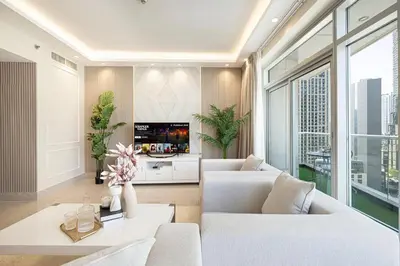 a living room with two white couches and a tv at Stunning Burj and Fountain View - 2BR in Dubai