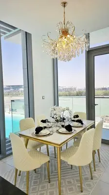 a dining room with a table with chairs and a chandelier at Spectacular Lagoon Apartment in Dubai