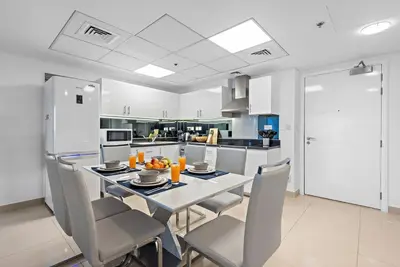 a kitchen with a table and chairs in a kitchen at First Class 1BR Modern & Stylish Living in Dubai