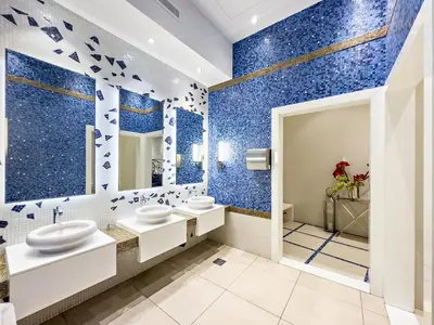 a bathroom with blue walls and white fixtures at Dubai 2BR Flat, Marina Views, Pool Access, Parking, Walk to Mall in Dubai