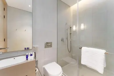a bathroom with a toilet and a glass shower at Maison Privee - Luxury Living w/ Superb Sea Views in Address JBR in Dubai