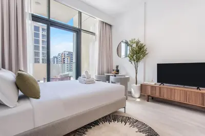 a white bedroom with a large bed and a large window at Lux Stu Bright Urban Escape Stay Near Downtown in Dubai
