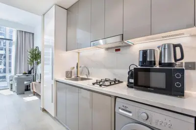a kitchen with a sink and a microwave at Lux Stu Bright Urban Escape Stay Near Downtown in Dubai