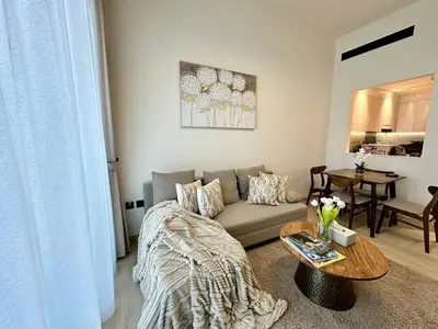 a living room with a couch and a table at Cozy Elegant 1br Balcony, Pool Access, Parking in Dubai